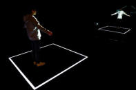 A staff member uses a projector to display the knitting pattern at the Adidas Knit for You store in Berlin, Germany March 7, 2017. REUTERS/Fabrizio Bensch