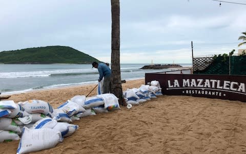 Sandbags are deployed on the beach to protect a restaurant in Mazatlan, Sinaloa state, from Hurricane Willa - Credit: Daniel Slim/AFP