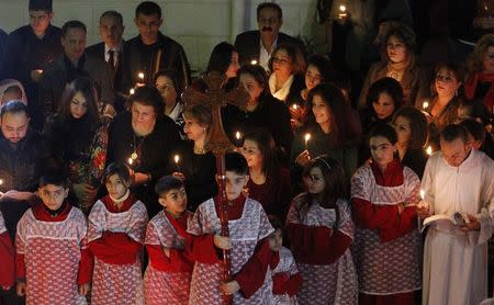 Iraqi Christians pray during a mass on Christmas eve at Sacred Heart Catholic Church in Baghdad December 24, 2014. REUTERS/ Thaier Al-Sudani