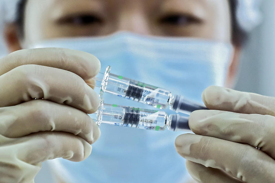 In this photo released by Xinhua News Agency, a medical worker inspects COVID-19 inactivated vaccines at a packaging plant of the Beijing Biological Products Institute Co., Ltd. in Beijing on Dec. 25, 2020. China on Wednesday, Feb. 3 announced a plan to provide 10 million coronavirus vaccine doses to developing nations through the global COVAX initiative. (Zhang Yuwei/Xinhua via AP)