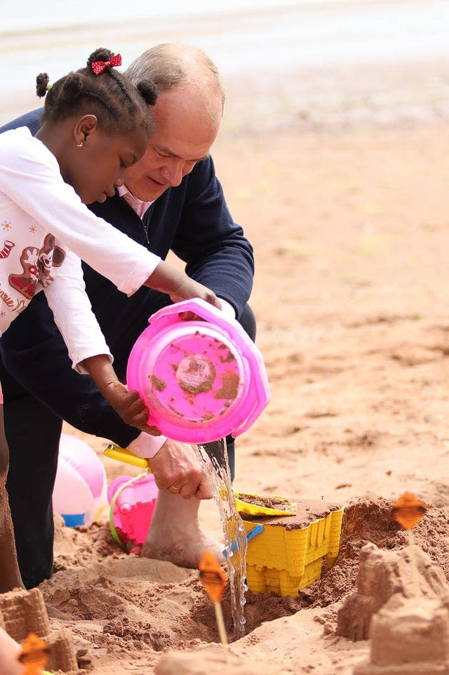 Liberal Democrats leader Sir Ed Davey builds sandcastles with children at a beach in Devon