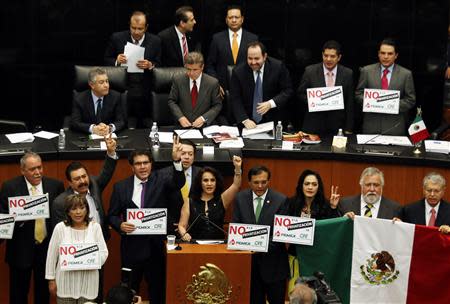 Senators of the Party of the Democratic Revolution (PRD) hold placards reading "No to the privatization of Pemex" while interrupting a debate on an energy reform bill at the Senate in Mexico City December 9, 2013. REUTERS/Henry Romero