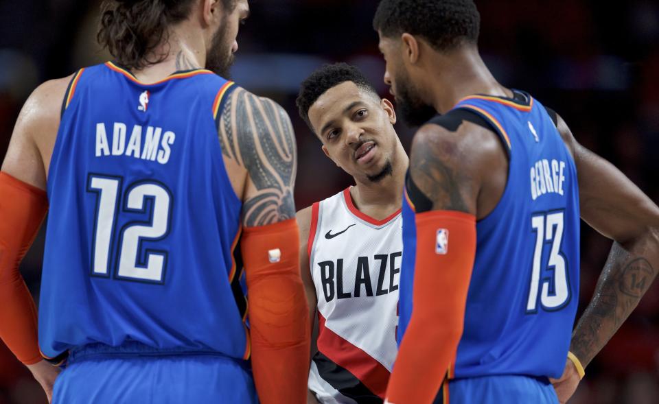 Portland Trail Blazers guard CJ McCollum, center, talks to Oklahoma City Thunder forward Paul George, right, and center Steven Adams during the first half of Game 2 of an NBA basketball first-round playoff series Tuesday, April 16, 2019, in Portland, Ore. (AP Photo/Craig Mitchelldyer)