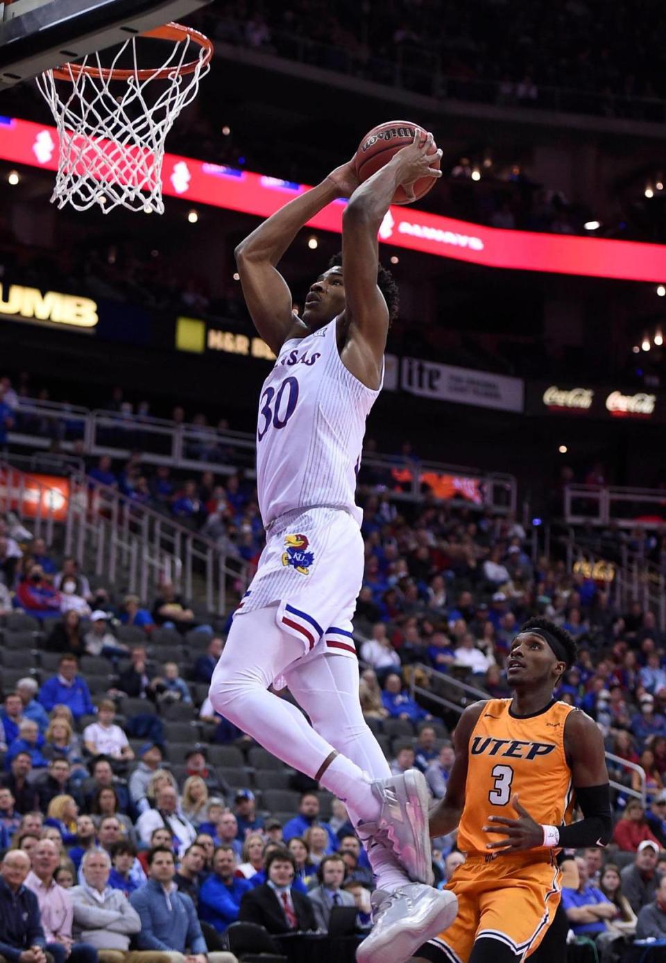 Kansas’ Ochai Agbaji flies by UTEP’s Keonte Kennedy for a dunk during the first half of the Jayhawks’ victory on Tuesday night at the T-Mobile Center in Kansas City.