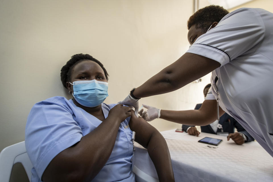 A member of hospital staff receives one of the country's first coronavirus vaccinations using AstraZeneca COVID-19 vaccine manufactured by the Serum Institute of India and provided through the global COVAX initiative, at Kenyatta National Hospital in Nairobi, Kenya Friday, March 5, 2021. Urgent calls for COVID-19 vaccine fairness rang through African countries on Friday as more welcomed or rolled out doses from the global COVAX initiative, with officials acutely aware their continent needs much more. (AP Photo/Ben Curtis)