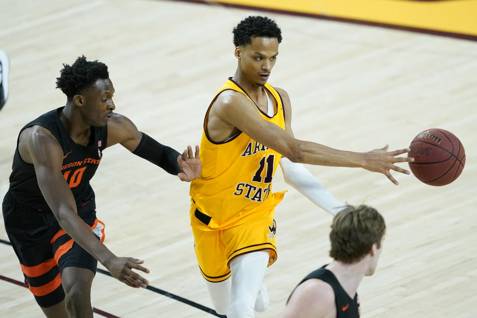 Arizona State guard Alonzo Verge Jr. (11) dishes off as Oregon State forward Warith Alatishe (10) defends during the second half of an NCAA college basketball game, Sunday, Feb. 14, 2021, in Tempe, Ariz.(AP Photo/Matt York)