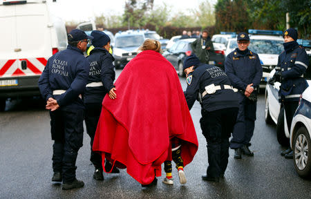 A person and a child are escorted by officers as local police confiscated a villa built illegally by an alleged Mafia family in Rome, Italy, November 20, 2018. REUTERS/Yara Nardi