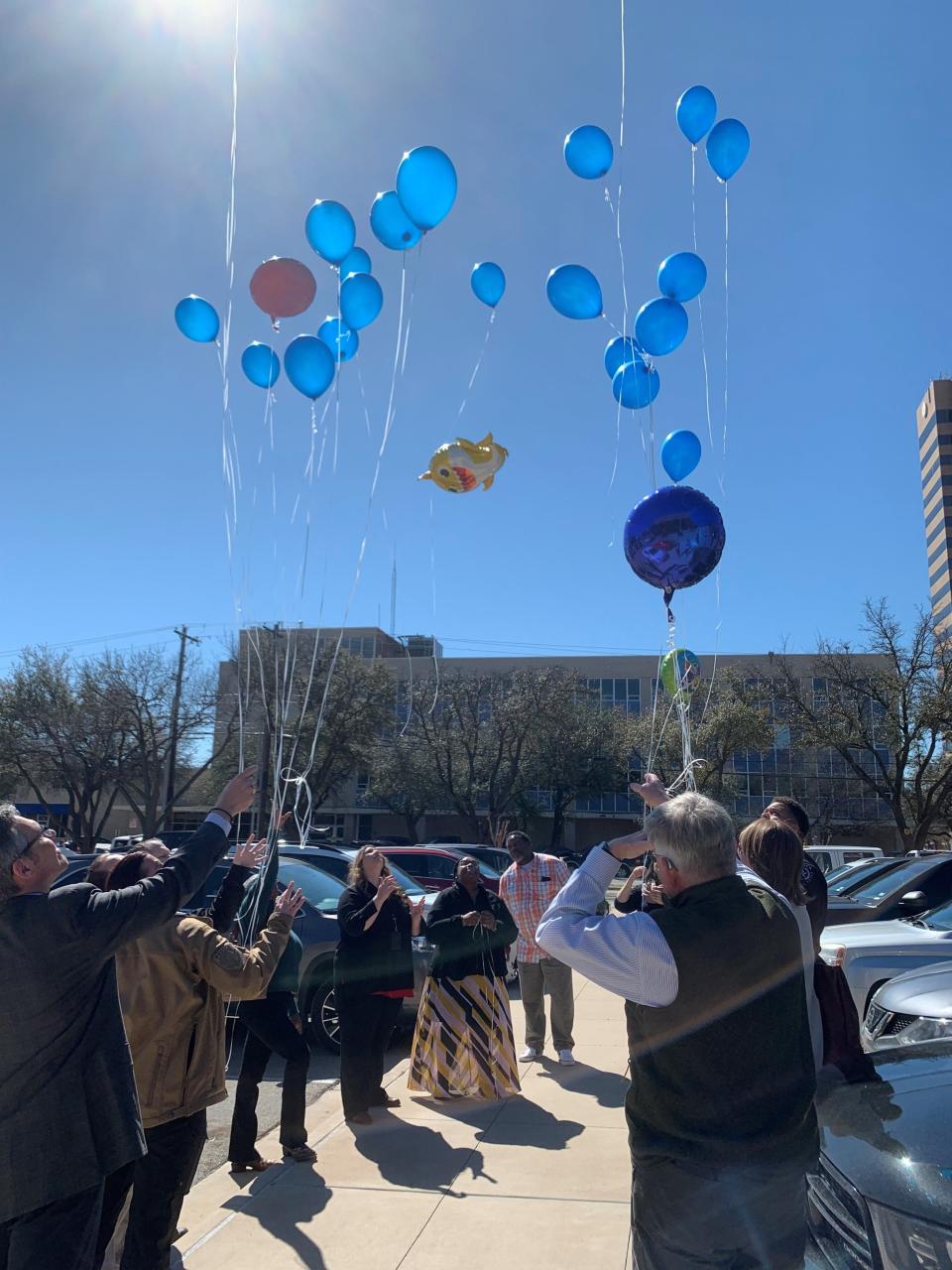Taylor County District Attorney's Office Investigator Tommy Pope, seen in the front right of the group, stands with law enforcement officers as they release balloons on Friday, March 1, 2024 in honor of Dairess Fuller Jr. who passed away due to malnutrition.