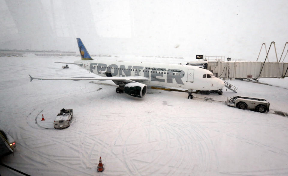 A Frontier airplane waits for passengers at O'Hare International Airport in Chicago, Thursday, Jan. 2, 2014. Another one to three inches of snow could fall across the Chicago metro area Thursday with even more falling in the southern part of the region, according to the National Weather Service. (AP Photo/Nam Y. Huh)