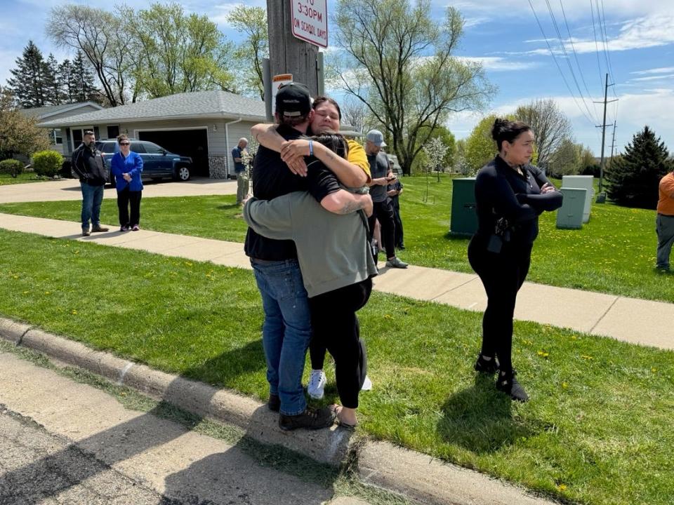 Parents hug on the road between the high school and the Intermediate Center in Mount Horeb, Wisconsin on Wednesday, May 1, 2024.