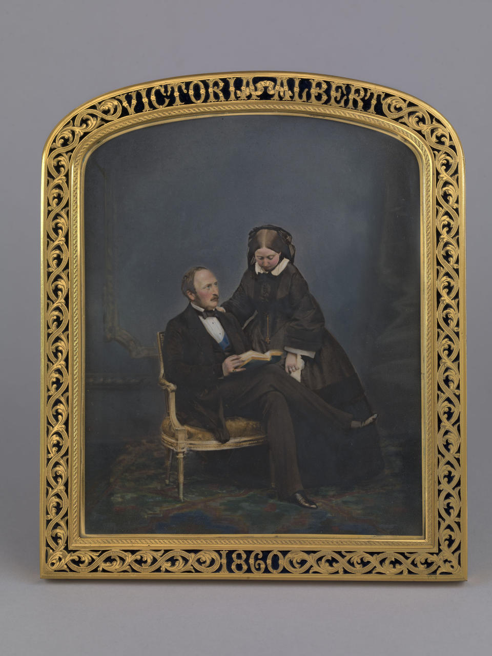 This image issued on Friday Aug. 23, 2019 by The Royal Collection shows a photograph of Queen Victoria and Prince Albert, 1860. In John Jabez Edwin Mayall's portrait of 1860, the Queen stands dutifully at her seated husband's side, her head bowed. This little-known version of the photograph, hand coloured and presented in a custom frame, was taken a year before Albert's untimely death in 1861. British royal documents, including images of Victoria’s leather-bound notebook, have been uploaded as part of thousands of documents and photos on the website www.albert.rct.uk that went online Friday to mark next week’s 200th anniversary of Albert’s birth. (The Royal Collection Trust via AP)