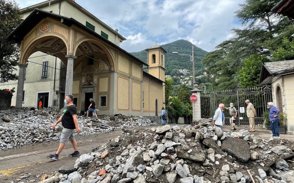 Passers-by stand next to the debris that a storm has washed up in Cernobbio, northern Italy - Bernhard Krieger/Avalon