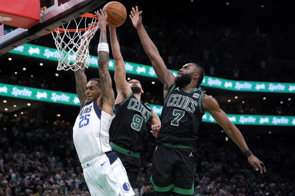 Dallas Mavericks forward P.J. Washington (25) is blocked by Boston Celtics' Derrick White (9) and Jaylen Brown (7) during the second half of Game 2 of the NBA Finals basketball series, Sunday, June 9, 2024, in Boston. (AP Photo/Steven Senne)