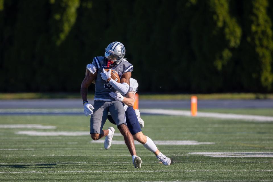 Monmouth receiver Dymere Miller picks up yardage on a record-setting afternoon against New Hampshire on Nov. 11, 2023 in West Long Branch.