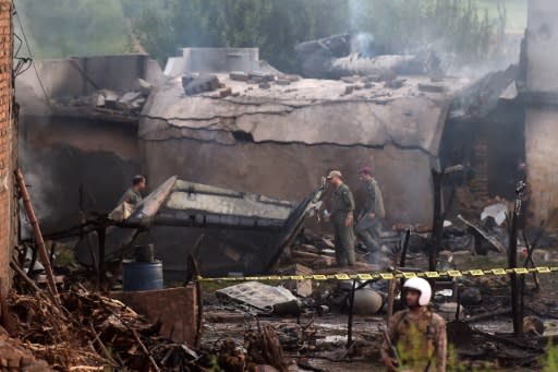 Pakistani soldiers cordon off the site where an aircraft crashed in Rawalpindi