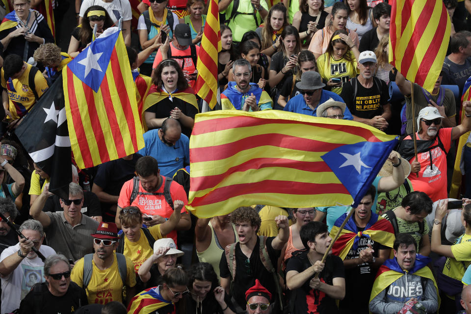 Protesters with "esteladas" or independence flags match into the city on the fifth day of protests over the conviction of a dozen Catalan independence leaders in Barcelona, Spain, Friday, Oct. 18, 2019. Various flights into and out of the region are cancelled Friday due to a general strike called by pro-independence unions and five marches of tens of thousands from inland towns are expected converge in Barcelona's center on Friday afternoon for a mass protest with students to and workers who are on strike. (AP Photo/Manu Fernandez)