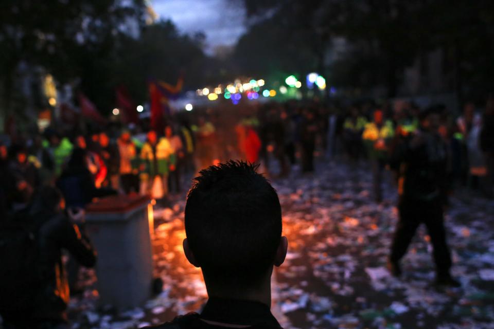 A man looks at a fire during a protest in Madrid November 4, 2013. Spain's labour unions called for an indefinite strike from Tuesday in Spain's capital for the street cleaning and park maintenance sectors in protest against announced layoffs that could affect around a thousand municipal workers, according to local media. REUTERS/Juan Medina(SPAIN - Tags: CIVIL UNREST BUSINESS EMPLOYMENT POLITICS)