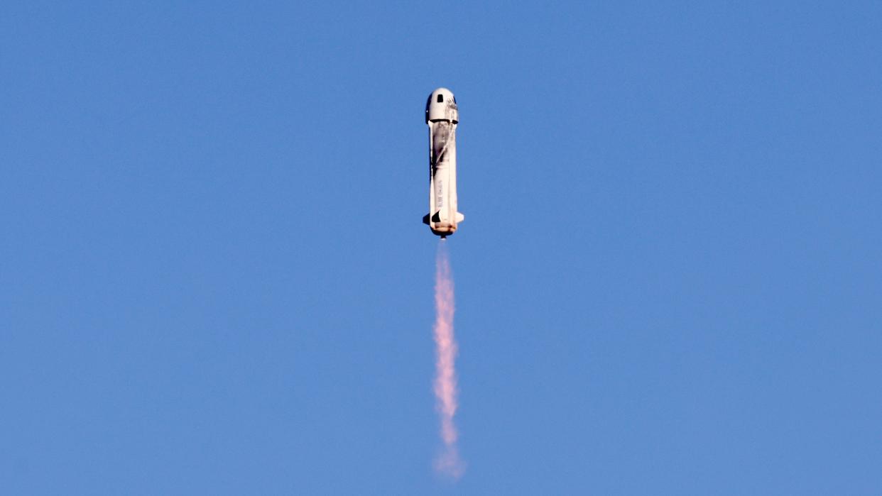  A tube-shaped rocket flying to space with blue sky as a background. 