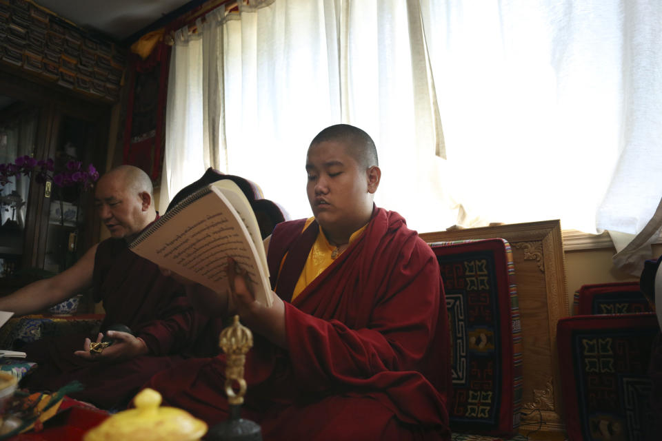 Jalue Dorje, recognized as the eighth reincarnation of the lama Terchen Taksham Rinpoche, recites prayers during a ceremony paying homage to Guru Rinpoche, the Indian Buddhist master who brought Tantric Buddhism to Tibet, on Monday, July 19, 2021, in Columbia Heights, Minn. . After finishing high school in 2025, Jalue will head to northern India and join the Mindrolling Monastery, more than 7,200 miles (11,500 kilometers) from his home. (AP Photo/Jessie Wardarski)