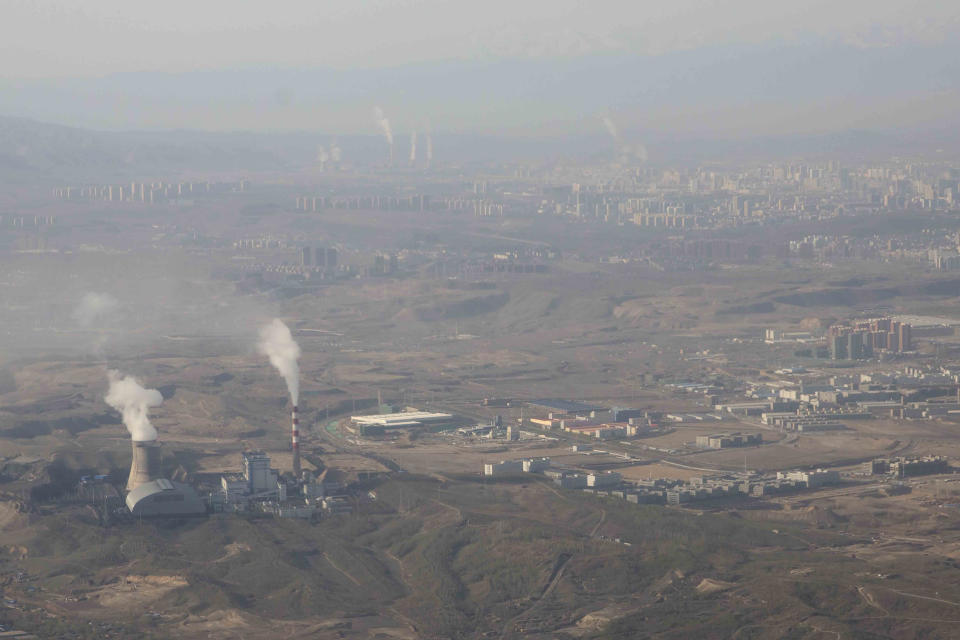 FILE - Smoke and steam rise from towers at the coal-fired Urumqi Thermal Power Plant as seen from a plane in Urumqi in western China's Xinjiang Uyghur Autonomous Region on April 21, 2021. At the G-7 summit, Germany will push its plan for countries to join together in a ‘climate club' to tackle global warming. This could put pressure on major polluters in the developing world, such as China and India, to step up their efforts or see their exports slapped with tariffs. (AP Photo/Mark Schiefelbein, File)