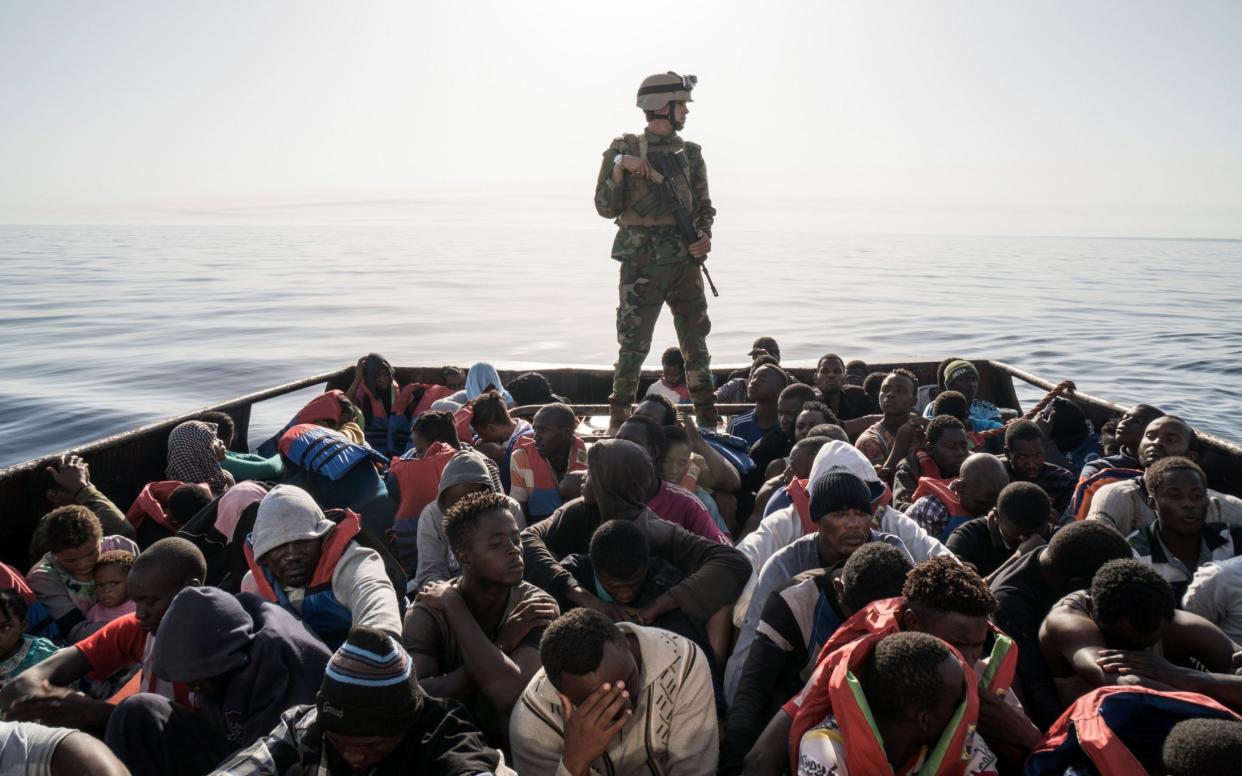 A Libyan coast guardsman stands on a boat during the rescue of 147 migrants attempting to reach Europe off the coastal town of Zawiyah, 45 kilometres west of the capital Tripoli, on June 27, 2017. - AFP