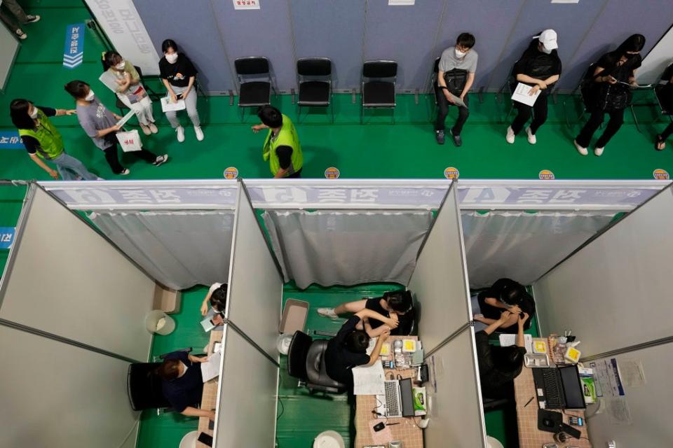 People receive the first dose of the Pfizer-BioNTech COVID-19 coronavirus vaccine at a vaccination center in Seoul (Copyright 2021 The Associated Press. All rights reserved.)