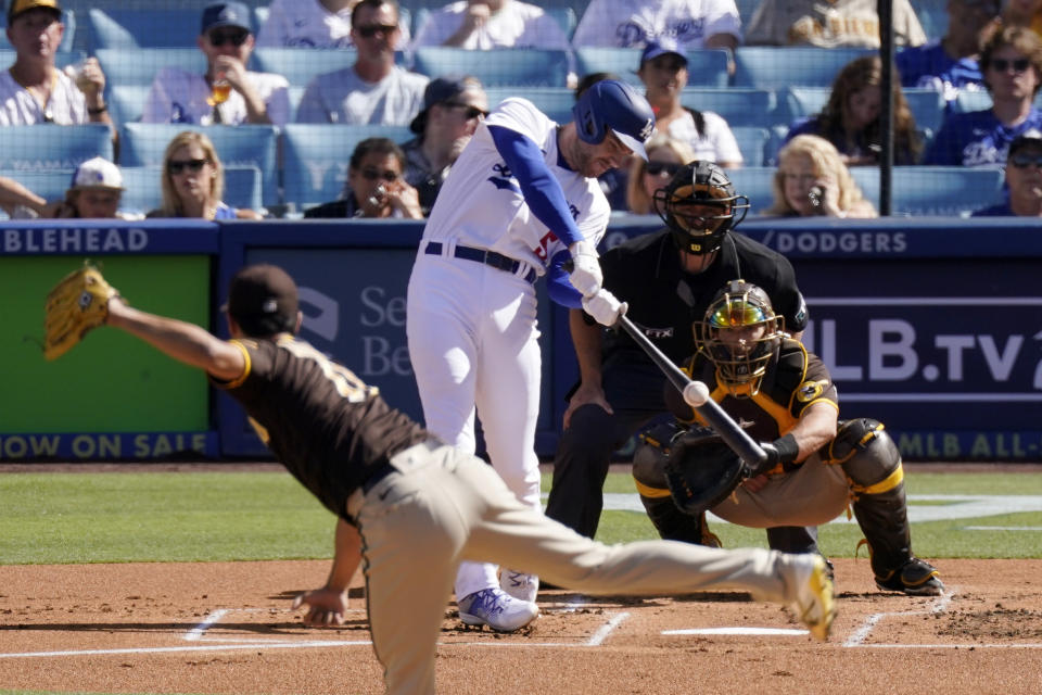 Los Angeles Dodgers' Freddie Freeman, second from left, hits a solo home run as San Diego Padres starting pitcher Yu Darvish, left, watches along with catcher Austin Nola, right, and home plate umpire Ben May during the first inning of a baseball game Saturday, July 2, 2022, in Los Angeles. (AP Photo/Mark J. Terrill)