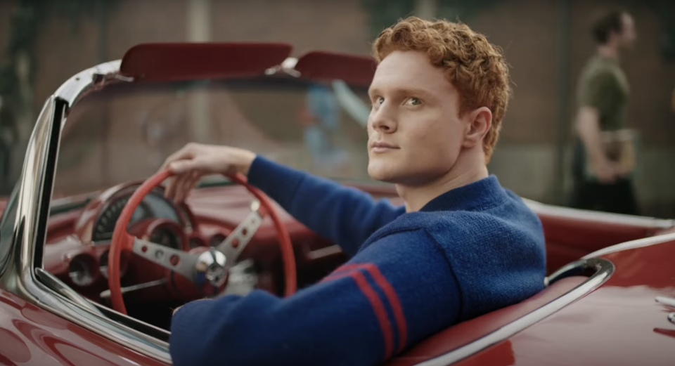 Young man sitting in the driver's seat of a sports convertible