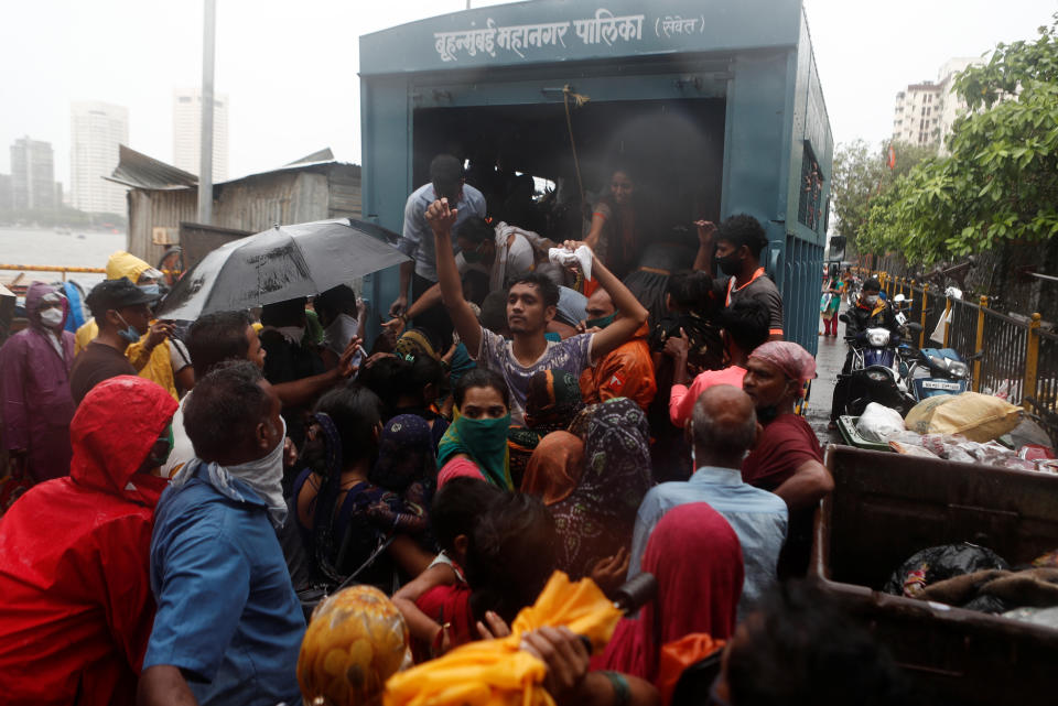 People scramble to enter a truck during an evacuation of a slum off the coast of the Arabian sea in Mumbai as cyclone Nisarga makes its landfall on the outskirts of the city on June, 3, 2020. REUTERS/Francis Mascarenhas