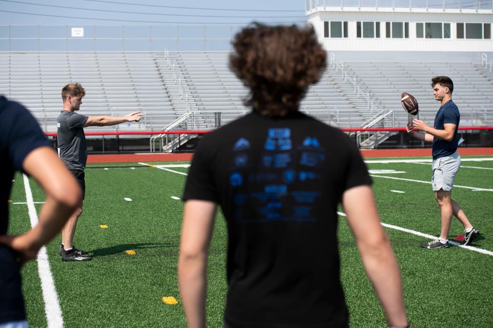 Brothers Cade Pribula (left) and Beau Pribula demonstrate a drill for students during their quarterback camp at Cumberland Valley High School May 21, 2023, in Mechanicsburg.