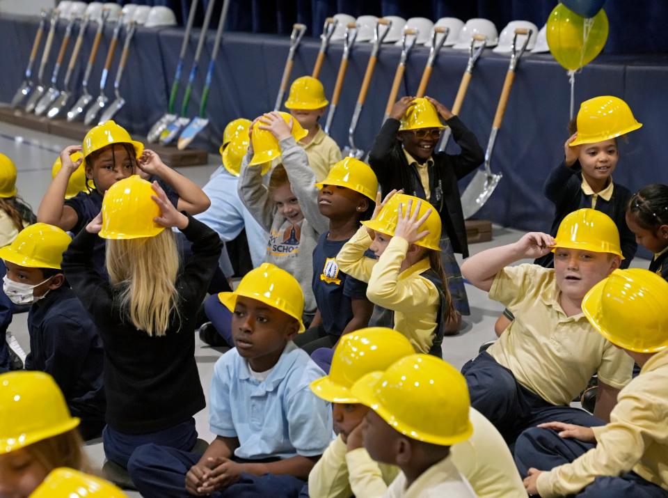 St. Mary School students wear plastic hard hats before singing the theme song to "Bob the Builder" on Monday morning during a groundbreaking ceremony at the school's Columbus German Village campus. The school is growing and preparing for renovations as well as adding a student health center through a partnership with Nationwide Children's Hospital.