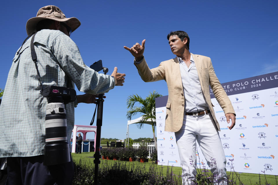 Argentine professional polo player Ignacio "Nacho" Figueras, right, greets journalists as he arrives for the 2024 Royal Salute Polo Challenge to Benefit Sentebale, Friday, April 12, 2024, in Wellington, Fla. Prince Harry, co-founding patron of the Sentebale charity, will play on the Royal Salute Sentebale Team. (AP Photo/Rebecca Blackwell)