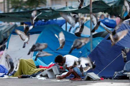 A migrant washes his face in a camp set by the Baobab aid group in Rome, Italy July 12, 2018. Pictures taken July 12, 2018. REUTERS/Yara Nardi