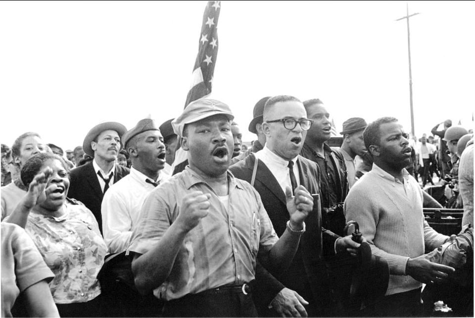 The Rev. Martin Luther King Jr. leads singing marchers from Selma to Montgomery in March 1965. On the right is SNCC Chairman John Lewis.