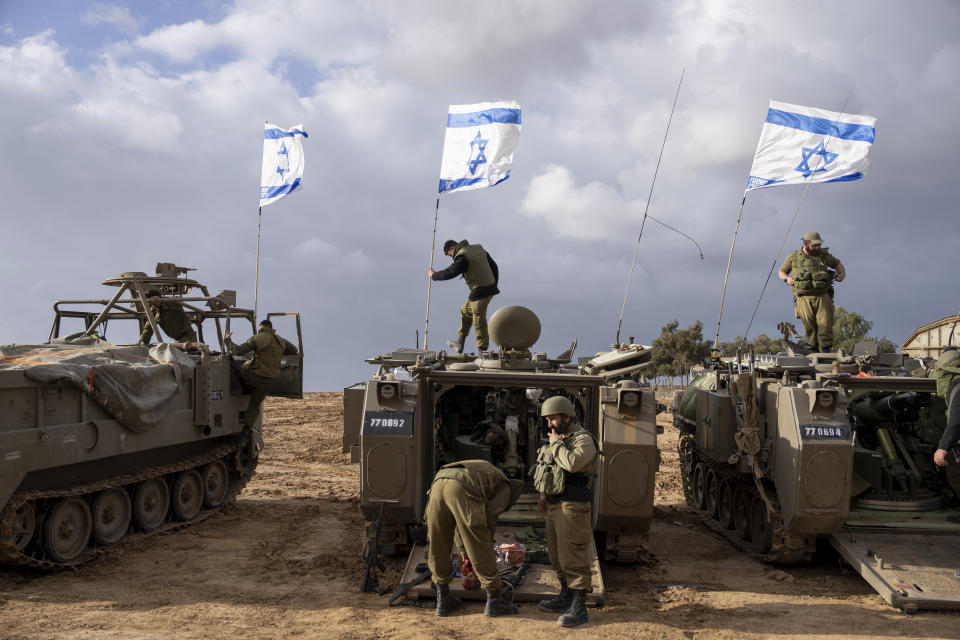 FILE - Israeli soldiers work on armored military vehicles along Israel's border with the Gaza Strip, in southern Israel, on Monday, Nov. 20, 2023. The Israeli military has rounded up hundreds of Palestinians across the northern Gaza Strip, separating families and forcing men to strip to their underwear before trucking some to an undisclosed location. The roundups have laid bare an emerging tactic in Israel's ground offensive in Gaza, experts say, as the military seeks to solidify control in evacuated areas in the north and collect intelligence about Hamas operations nearly 10 weeks after the group's deadly Oct. 7 attack on southern Israel. (AP Photo/Ohad Zwigenberg, File)