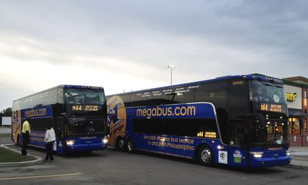 Two Megabus buses serving between Washington, DC and Toronto, Ontario cross paths at a rest stop in Bath, New York June 3, 2012. REUTERS/Hyungwon Kang