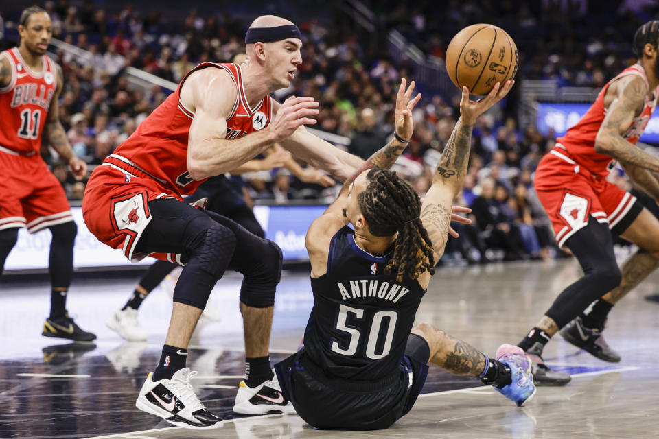 Orlando Magic guard Cole Anthony (50) tries to shoot while defended by Chicago Bulls guard Alex Caruso (6) during the first half of an NBA basketball game, Saturday, Jan. 28, 2023, in Orlando, Fla. (AP Photo/Kevin Kolczynski)