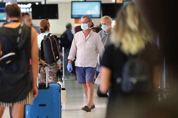 Passengers are seen at Sydney International Airport wearing face masks.