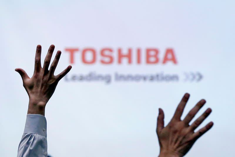 FILE PHOTO: Reporters raise their hands for a question during a Toshiba news conference in Tokyo