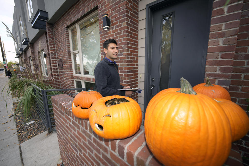 Vote canvasser Joshua Posner makes a stop at a home along 35th Street Tuesday, Nov. 1, 2022, in northeast Denver. Coloradans are taking the state's housing crisis into their own hands by turning to local and statewide ballot measures intended to quell the soaring costs. (AP Photo/David Zalubowski)