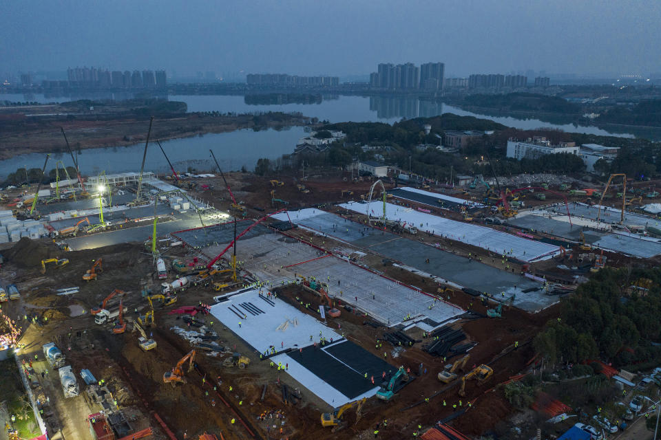 In this Tuesday, Jan. 28, 2020, photo, construction workers labor at the site of the Huoshenshan temporary field hospital being built in Wuhan in central China's Hubei Province. China as of Wednesday has more infections of a new virus than it did in with SARS, though the death toll is still lower. (Chinatopix via AP)