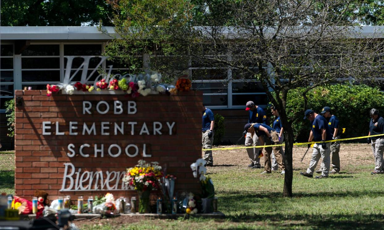 <span>Investigators search for evidence outside Robb elementary school in Uvalde, Texas on 25 May 2022.</span><span>Photograph: Jae C Hong/AP</span>