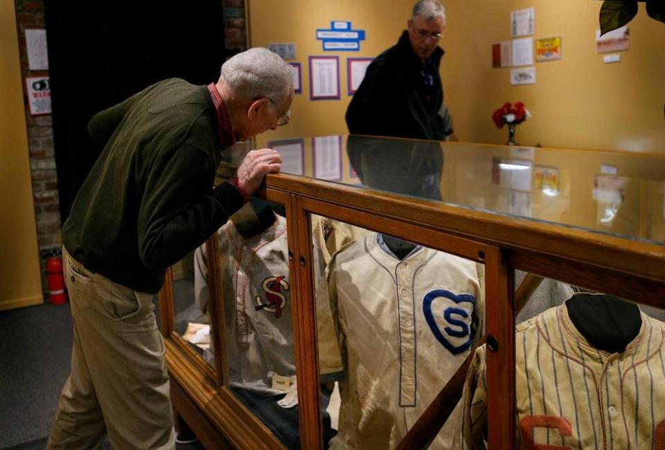 Cuno Barragan of Sacramento, left, former Sacramento Solons catcher from 1957-1960 and Chicago Cubs catcher from 1961-1963, and Tom Crisp of Davis examine historic baseball jerseys at the “History of Baseball in Sacramento” exhibit at the Folsom Historical Museum in Folsom on Feb. 25. The exhibit features memorabilia from baseball teams in Sacramento, including jerseys, jackets, cards, bats, gloves, posters, etc. collected by Alan O’Connor.