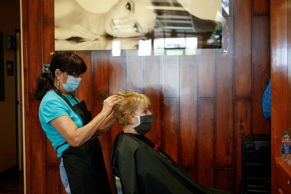 Image: Donna Ferraro cuts and styles Jan Campbell?s hair at Passions Salon during the phased reopening from the coronavirus disease (COVID-19) restrictions, in Cave Creek (Nicole Neri / Reuters file)