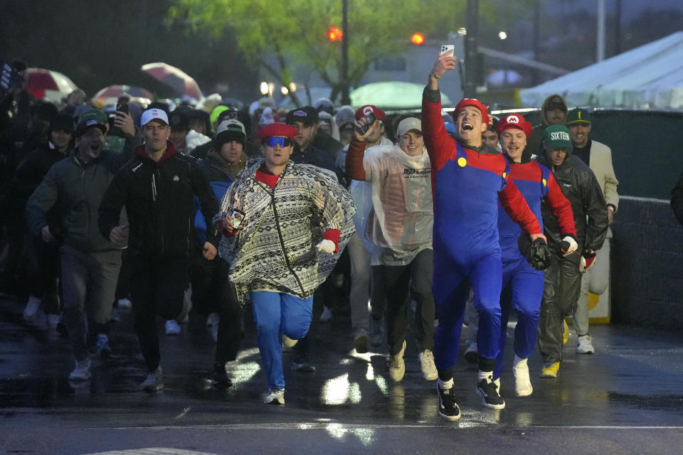 Fans run onto the course prior to the continuation of second round of the Phoenix Open golf tournament Saturday, Feb. 10, 2024, in Scottsdale, Ariz. (AP Photo/Ross D. Franklin)