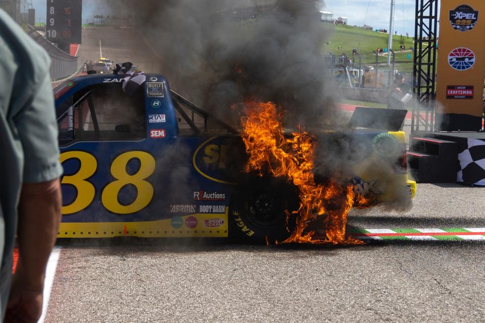 Fire spreads over Zane Smith's truck after his celebratory burnout for winning the NASCAR truck race at Circuit of the Americas on Saturday.