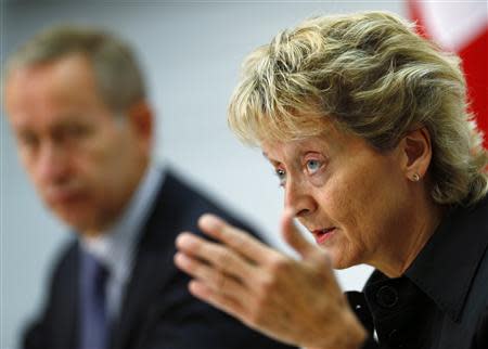 Swiss Finance Minister Eveline Widmer-Schlumpf speaks to media next to Swiss Secretary of State and government negotiator Michael Ambuehl during a news conference in Bern August 30, 2013. REUTERS/Ruben Sprich