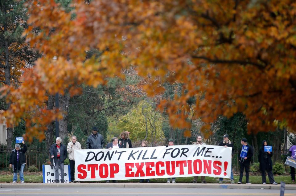 People stand outside the Governor's Mansion during a prayer vigil against the death penalty in 2023 in Oklahoma City.