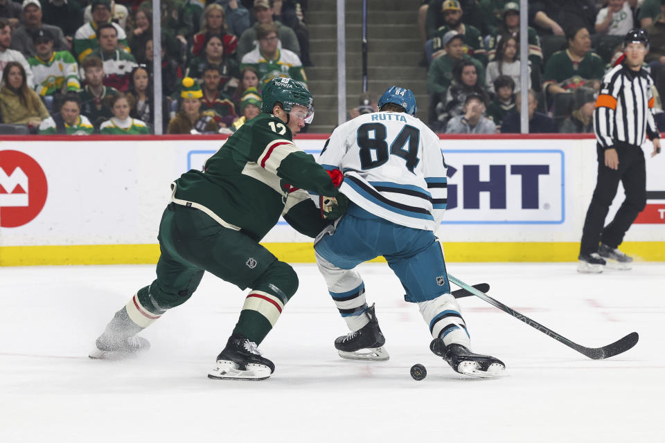 Minnesota Wild left wing Matt Boldy and San Jose Sharks defenseman Jan Rutta (84) go after the puck during the first period of an NHL hockey game, Sunday, March 3, 2024, in St. Paul, Minn. (AP Photo/Stacy Bengs)