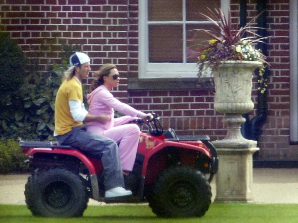 avid Beckham and Victoria Beckham ride on a quadbike at their Hertfordshire home on April 12, 2004.